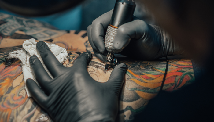 Tatuador concentrado en la obra de arte que está elaborando